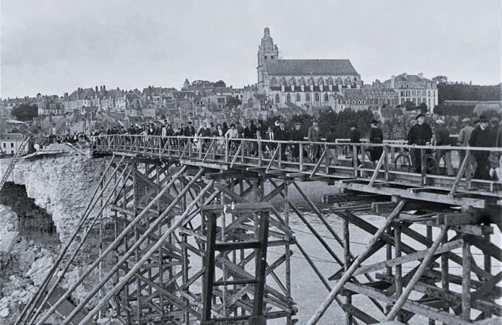 Photo d’archive, avec le pont Jacques-Gabriel partiellement détruit et temporairement remplacé par une passerelle en bois.