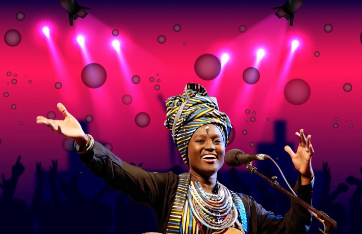 Une femme en habits traditionnels africains chante sur scène.