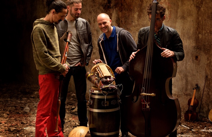 Le groupe La machine pose en souriant avec ses instruments dans une pièce en ruine.