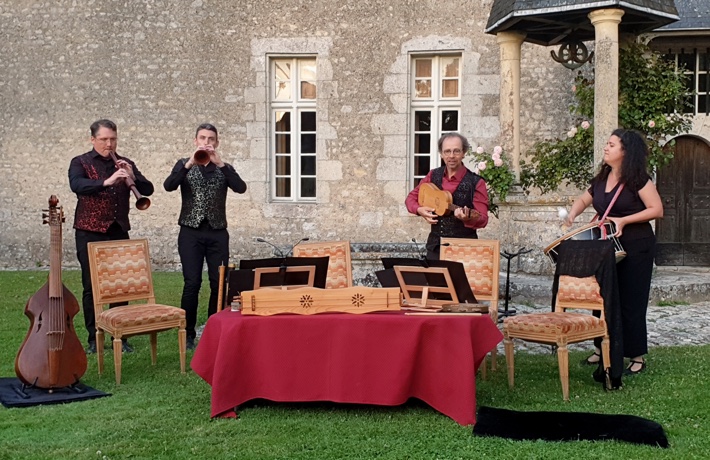 Le groupe « Banquet du Roy » pose avec ses instruments en extérieur.