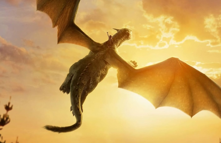 Affiche du film : Elliot le dragon s’envole avec Peter sur son dos. L’une des ailes masque le soleil couchant.