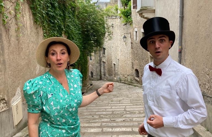 Deux personnes dont l’une jouant Arsène Lupin posent en costume dans l’un des degrés du vieux Blois.