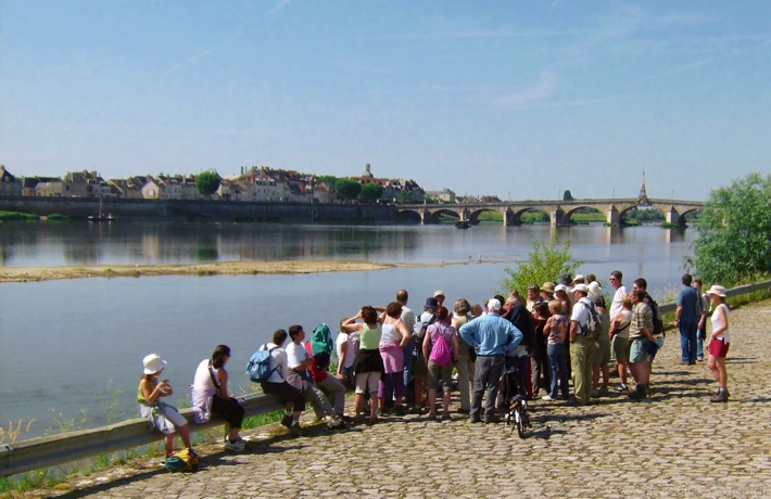 Un groupe de plusieurs dizaines de personnes suit une visite guidée en bord de Loire.