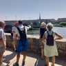 Une personne mène une visite autour de 5 autres, sur les quais, en direction du pont Jacques-Gabriel.