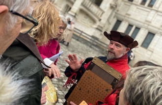 Un homme costumé anime le jeu dans la cour du château.