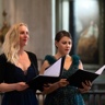 Deux chanteuses tenant leur livret au milieu d’une église.